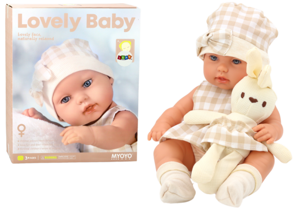 Baby doll in a carrier, a bunny, in a checkered outfit, beige