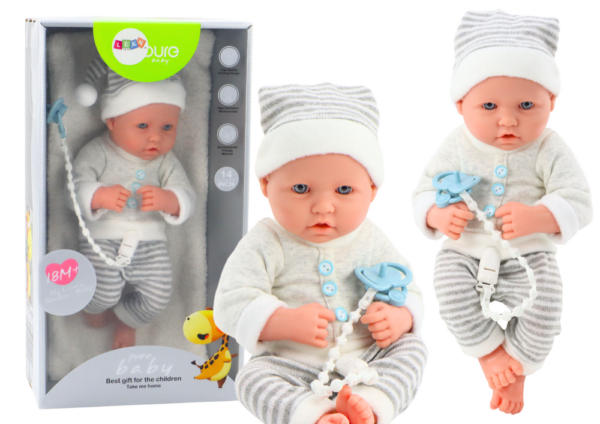 Baby doll in white and gray striped clothes, hat, pacifier, quilt